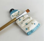Handgefertigte Pinselablage aus Keramik, Farbtube mit kleinen blauen Blütenverzierungen